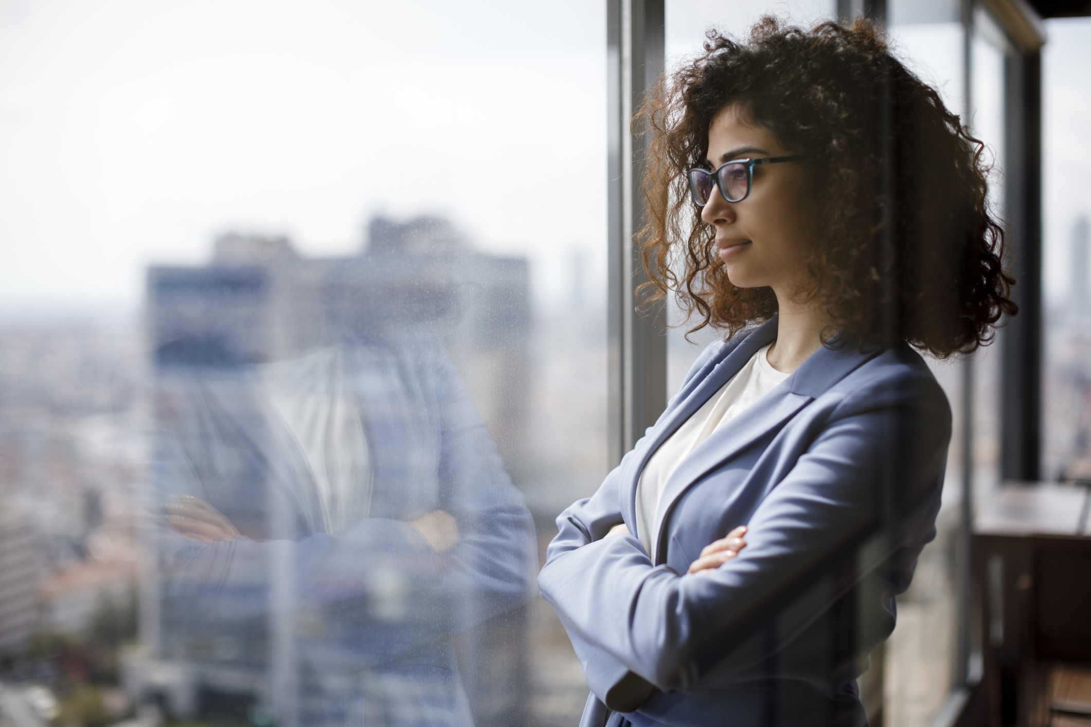 A businesswoman looking through a window.