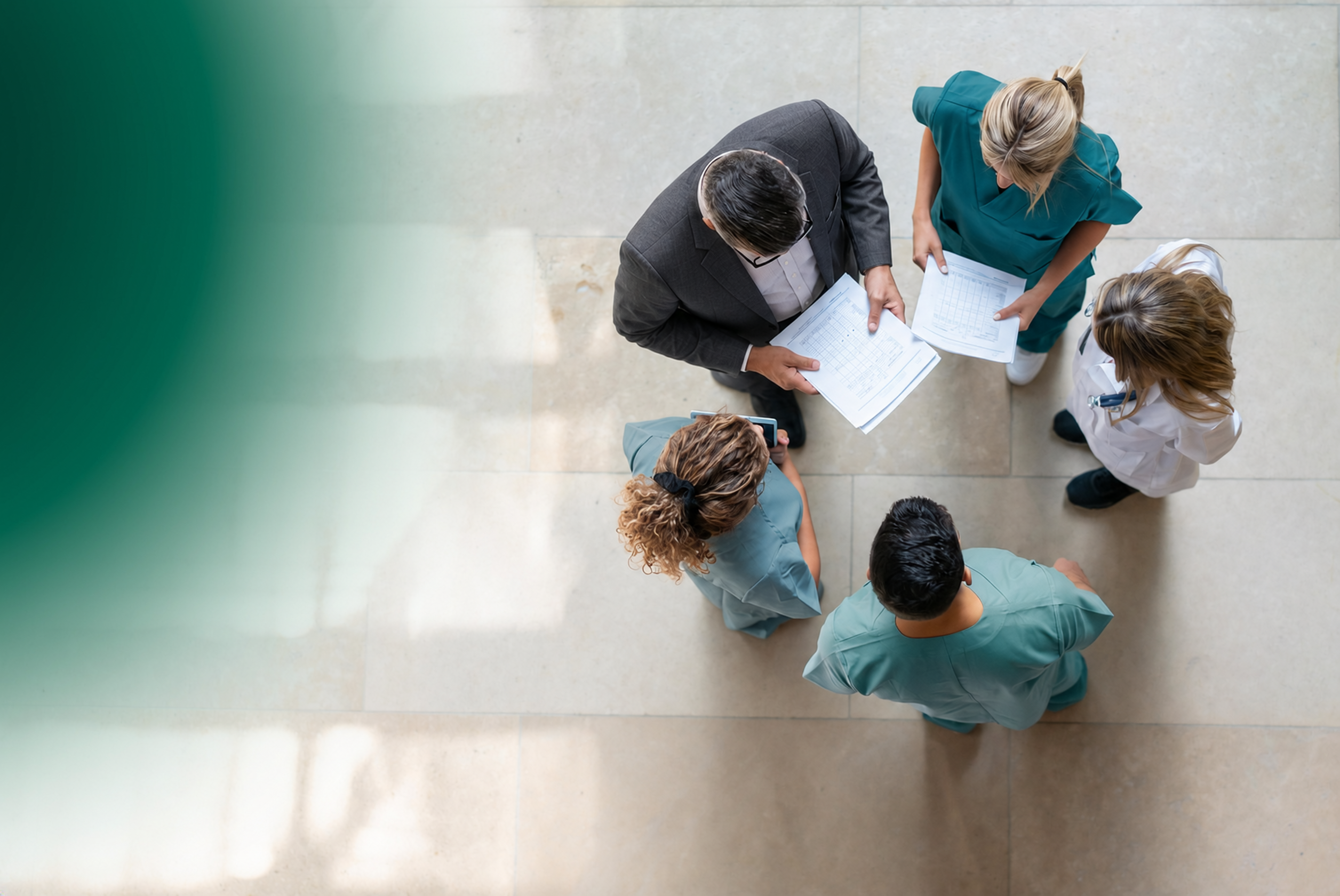 Healthcare professionals and a business-dressed colleague in a team discussion.