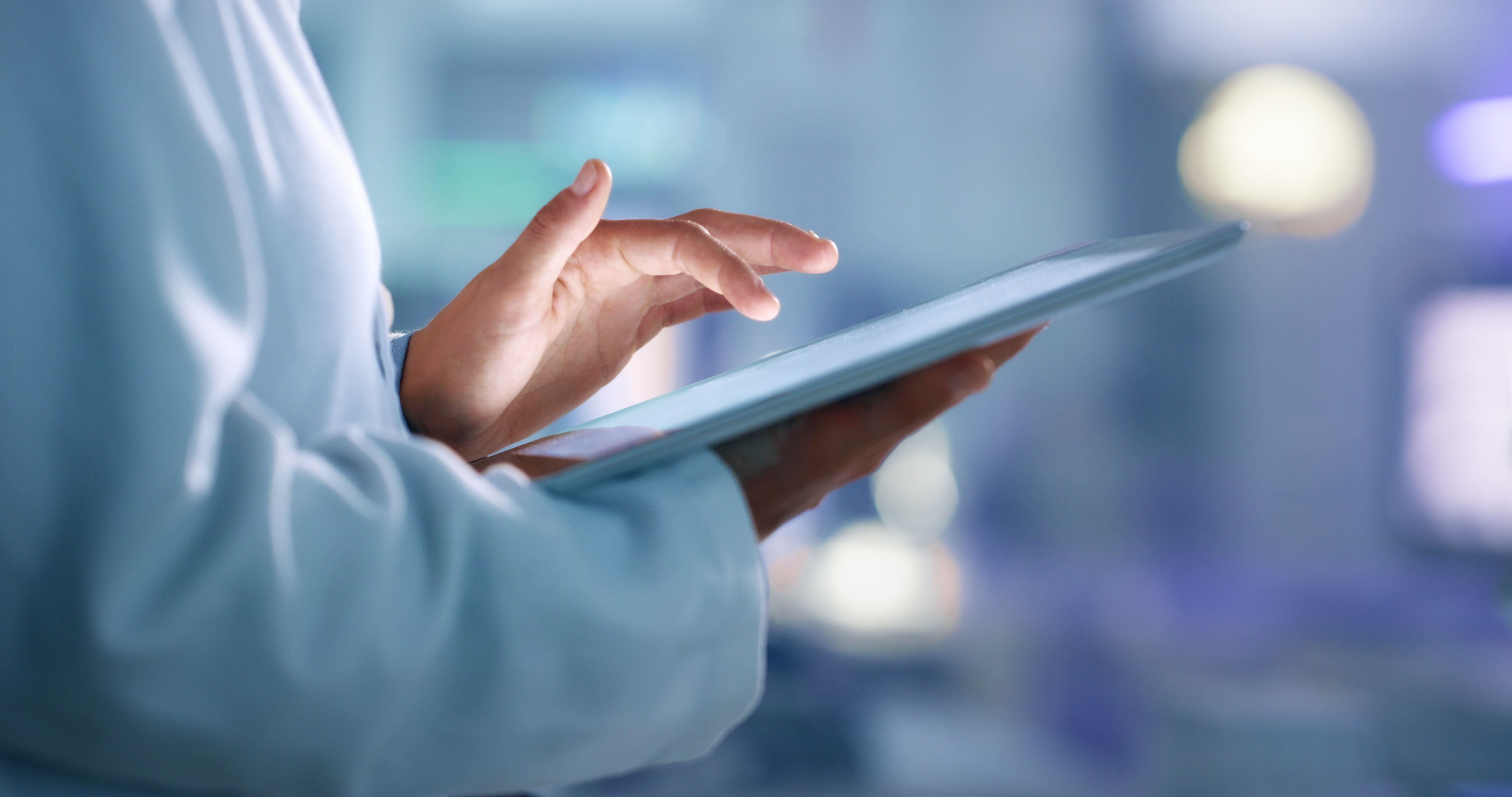 Hands reviewing information on a tablet.