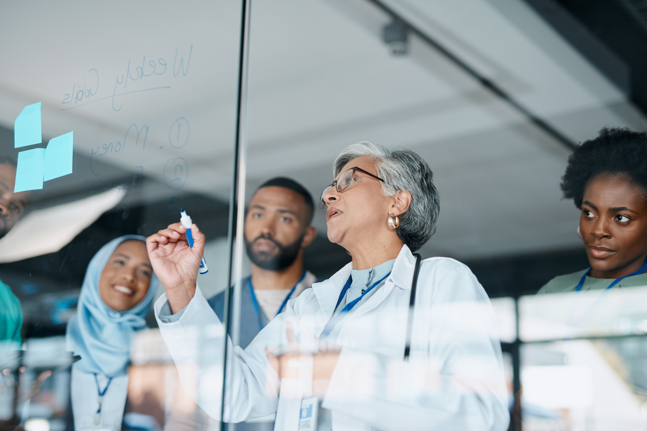 Healthcare colleagues in conversation by a window.